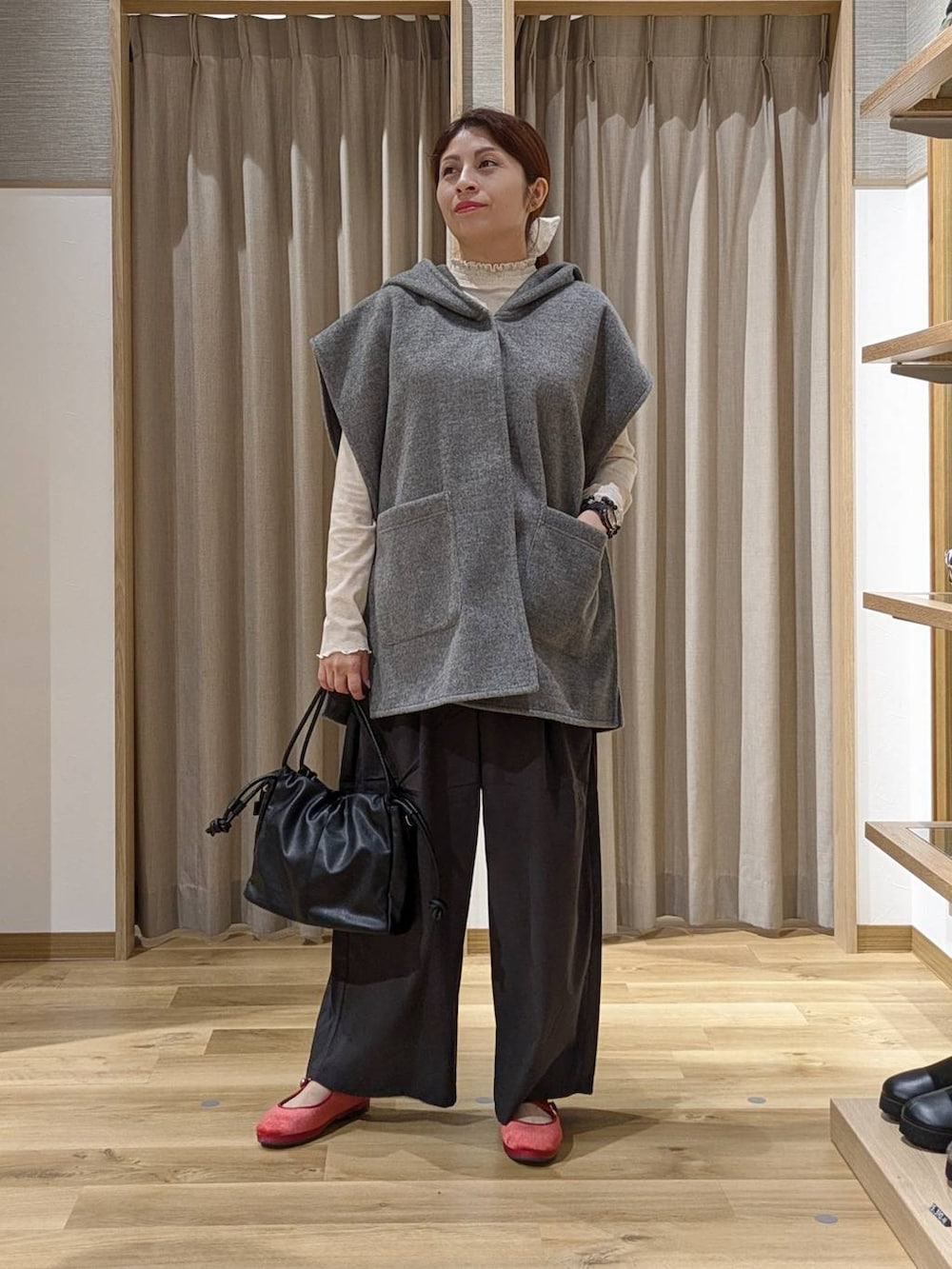 レッド系のその他シューズ、グレー系のその他アウター、ブラック系のショルダーバッグを着用したレディースの秋コーディネートの4枚目の写真