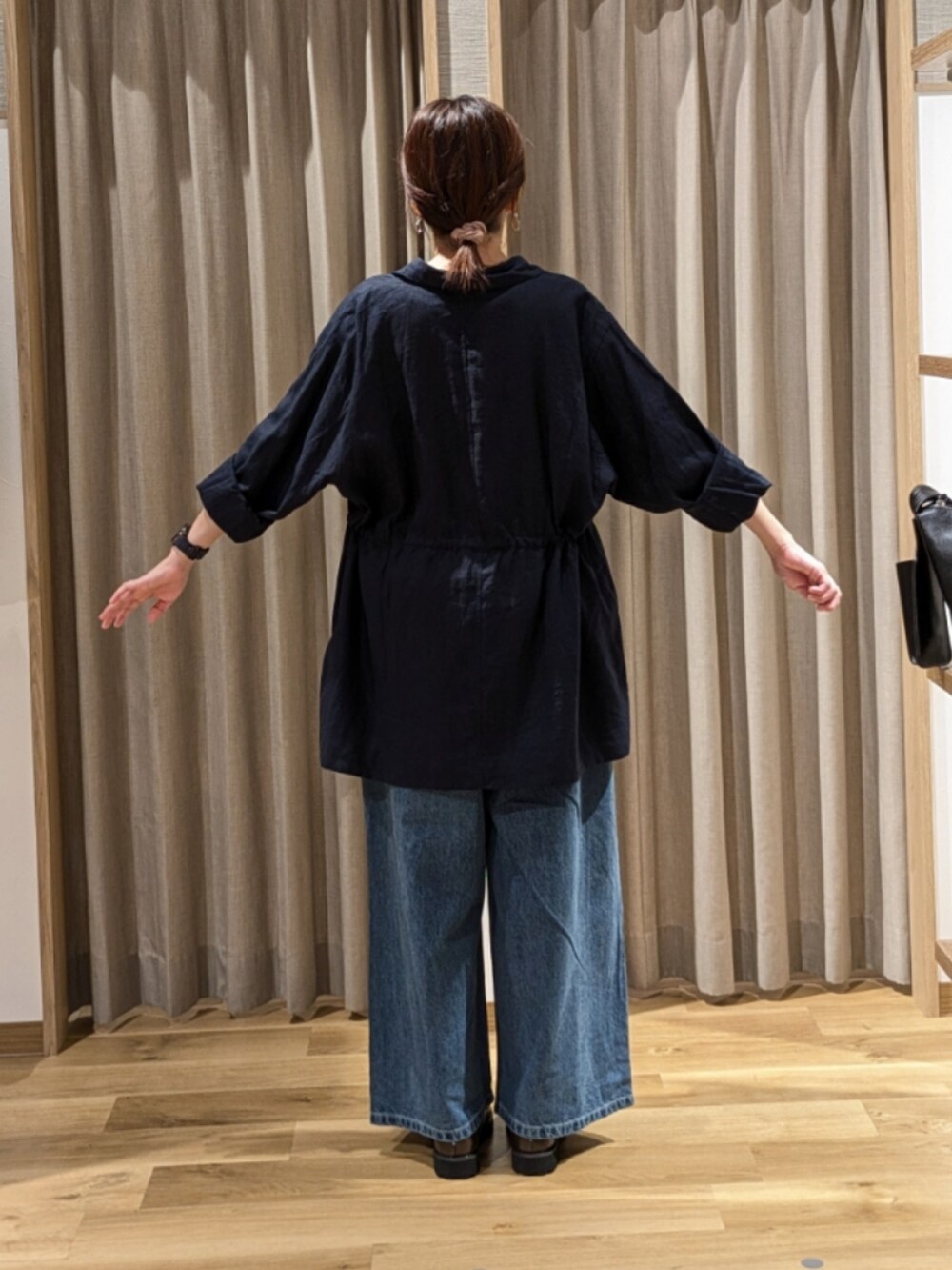 ブルー系のデニムパンツ、ブラウン系のローファー、ブルー系のその他アウターを着用したレディースの秋コーディネートの4枚目の写真