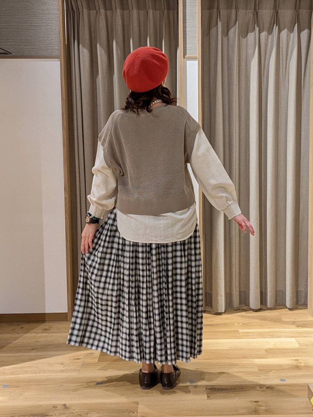 ブラウン系のローファー、ブラック系のスカート、ブラウン系のニット/セーターを着用したレディースの春コーディネートの2枚目の写真