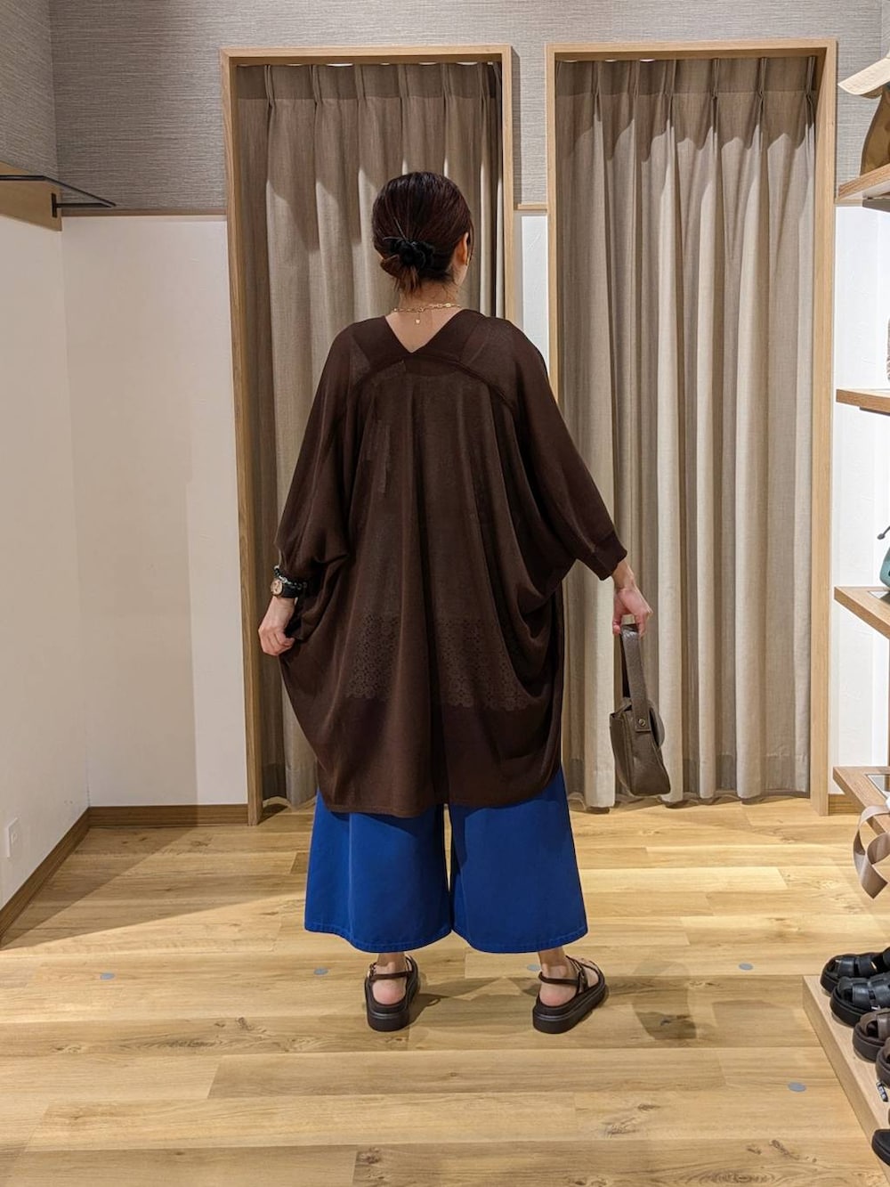ブラウン系のサンダル、ブルー系のその他パンツ、ブラウン系のショルダーバッグを着用したレディースの夏コーディネートの2枚目の写真