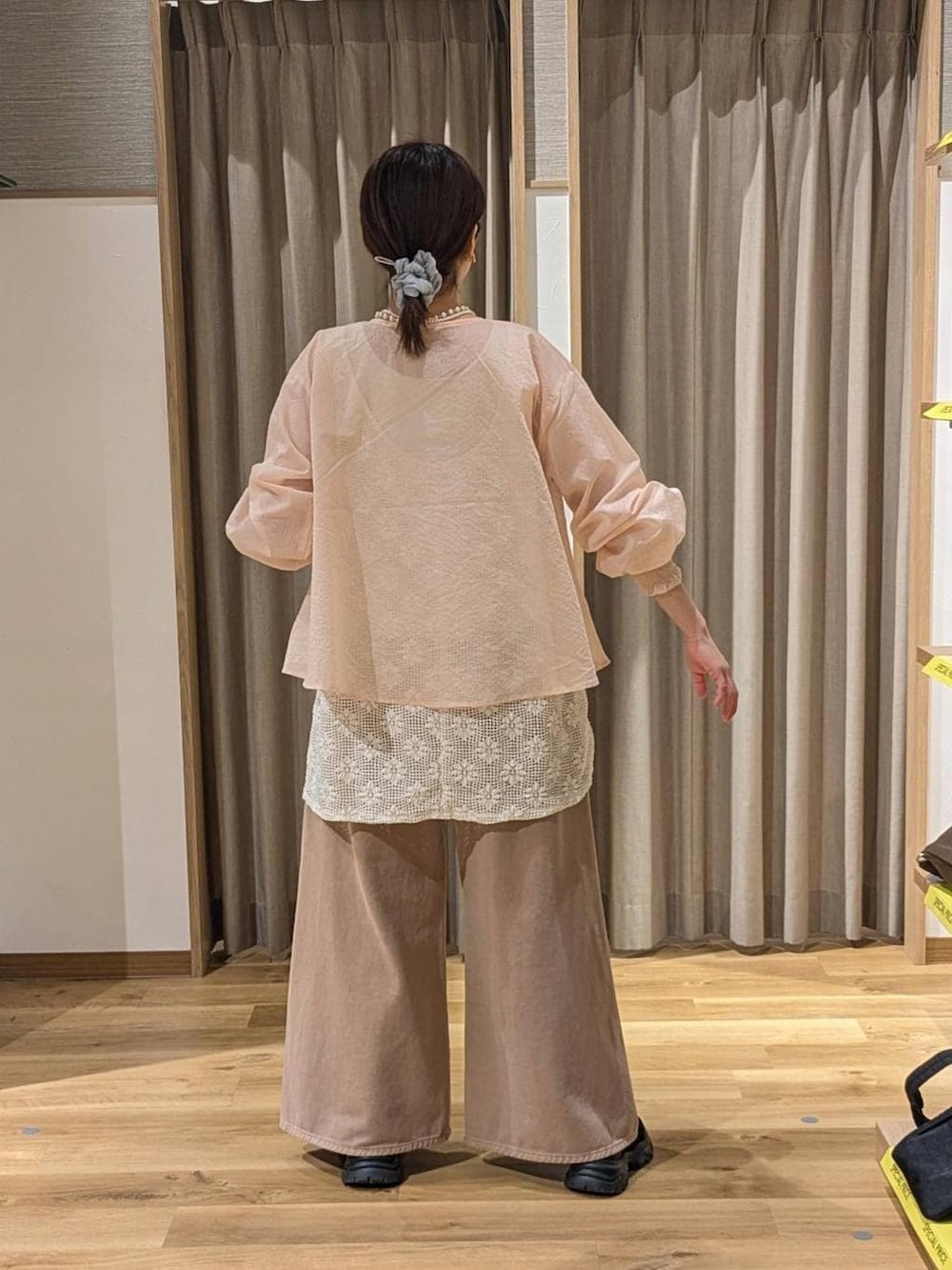 ベージュ系のデニムパンツ、ブラック系のスニーカー、ベージュ系のトートバッグを着用したレディースの春コーディネートの2枚目の写真