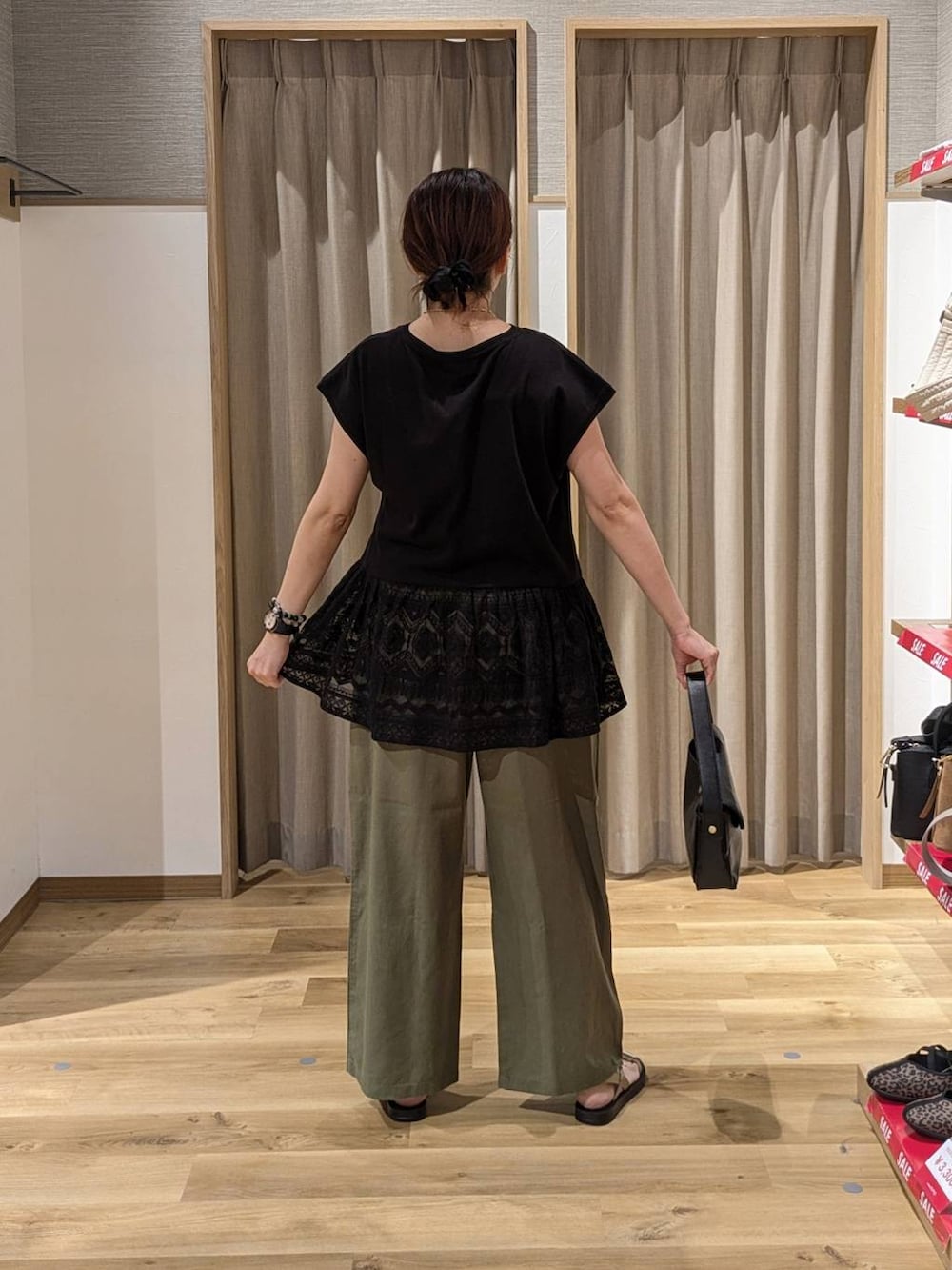 ゴールド系のサンダル、グリーン系のその他パンツ、ブラック系のTシャツ/カットソーを着用したレディースの夏コーディネートの2枚目の写真