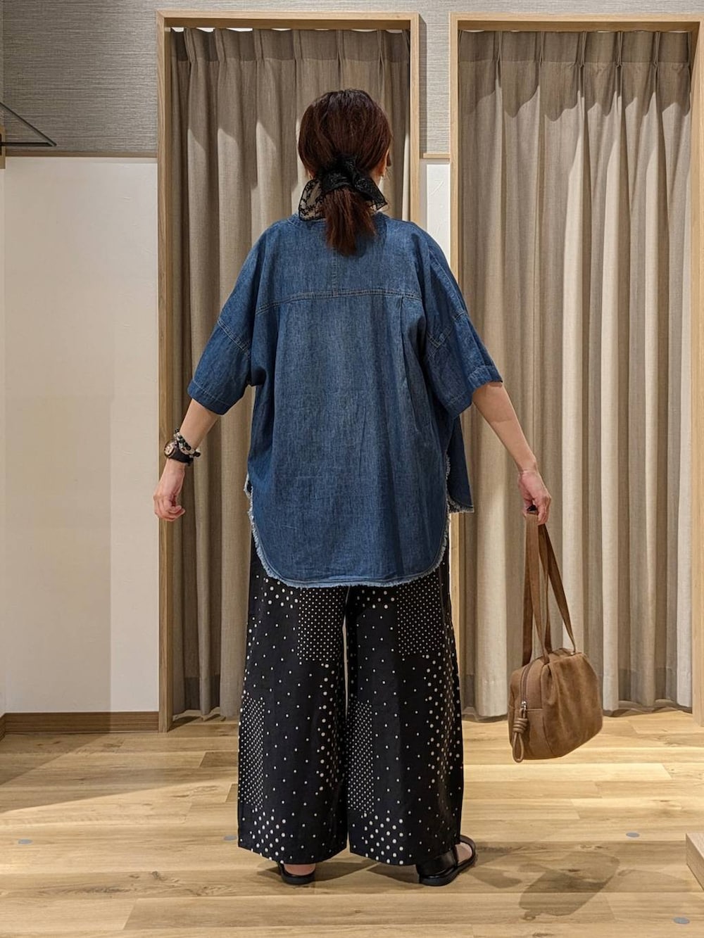 ブラウン系のショルダーバッグ、ベージュ系のニット/セーター、ベージュ系のタンクトップを着用したレディースの夏コーディネートの3枚目の写真