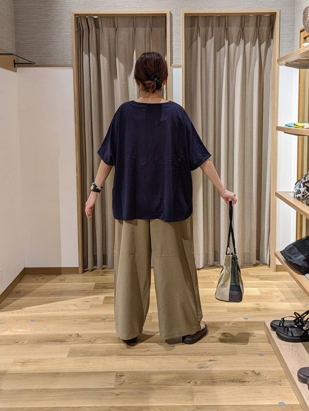 イエロー系のトートバッグ、ベージュ系のサンダル、ベージュ系のその他パンツを着用したレディースの夏コーディネートの2枚目の写真