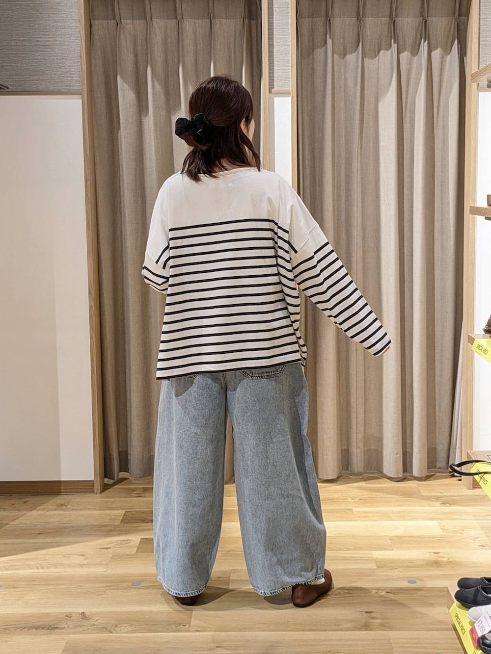 ブルー系のデニムパンツ、ベージュ系のトートバッグ、その他のTシャツ/カットソーを着用したレディースの春コーディネートの2枚目の写真