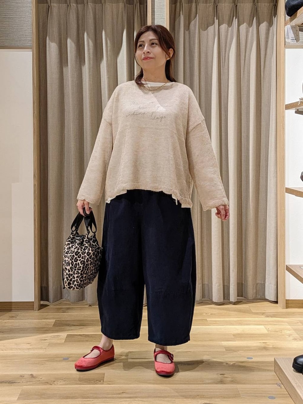 レッド系のその他シューズ、ベージュ系のニット/セーター、ホワイト系のTシャツ/カットソーを着用したレディースの秋コーディネートの4枚目の写真