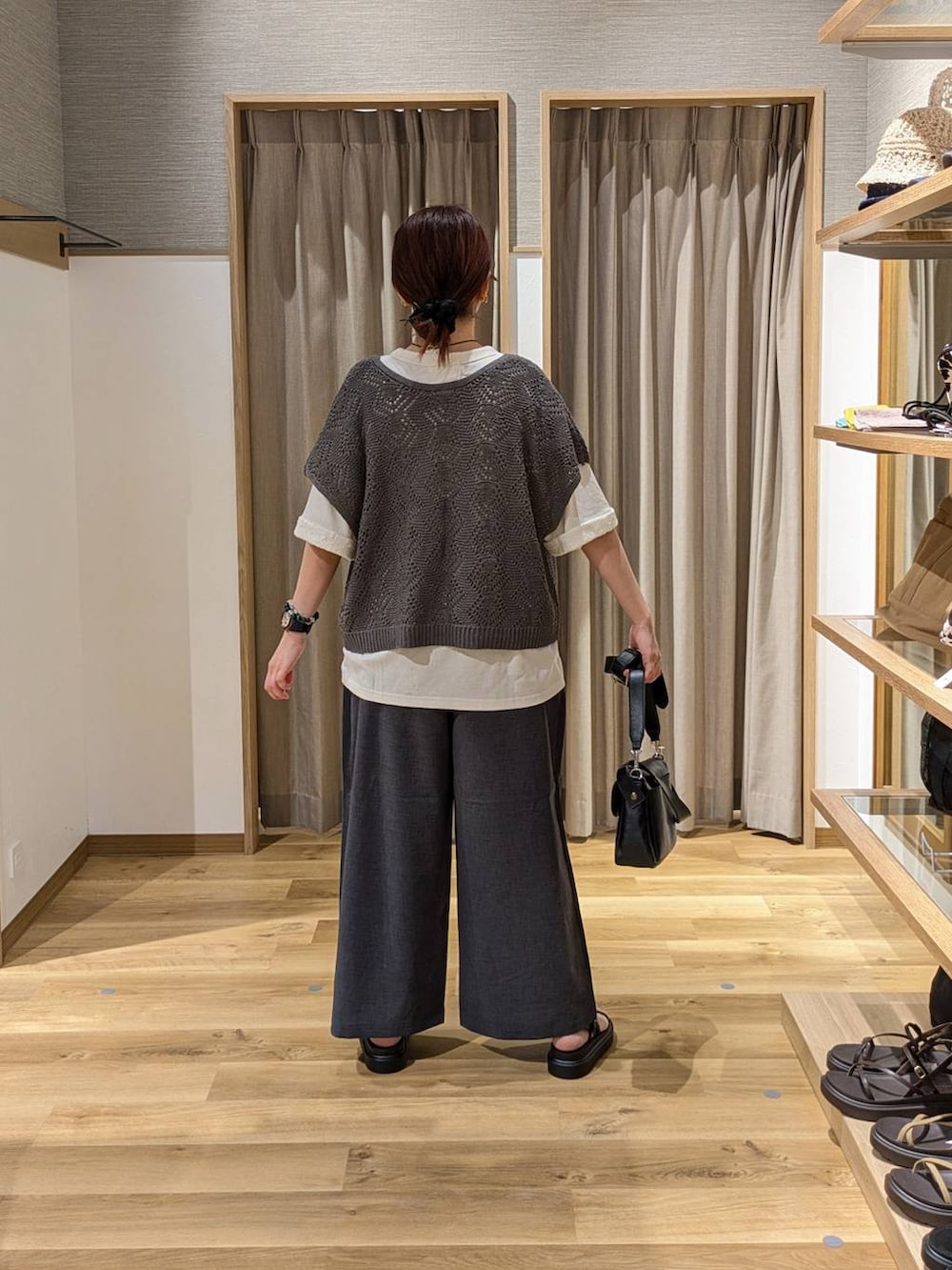 ブラウン系のサンダル、グレー系のその他パンツ、ブラック系のショルダーバッグを着用したレディースの夏コーディネートの2枚目の写真