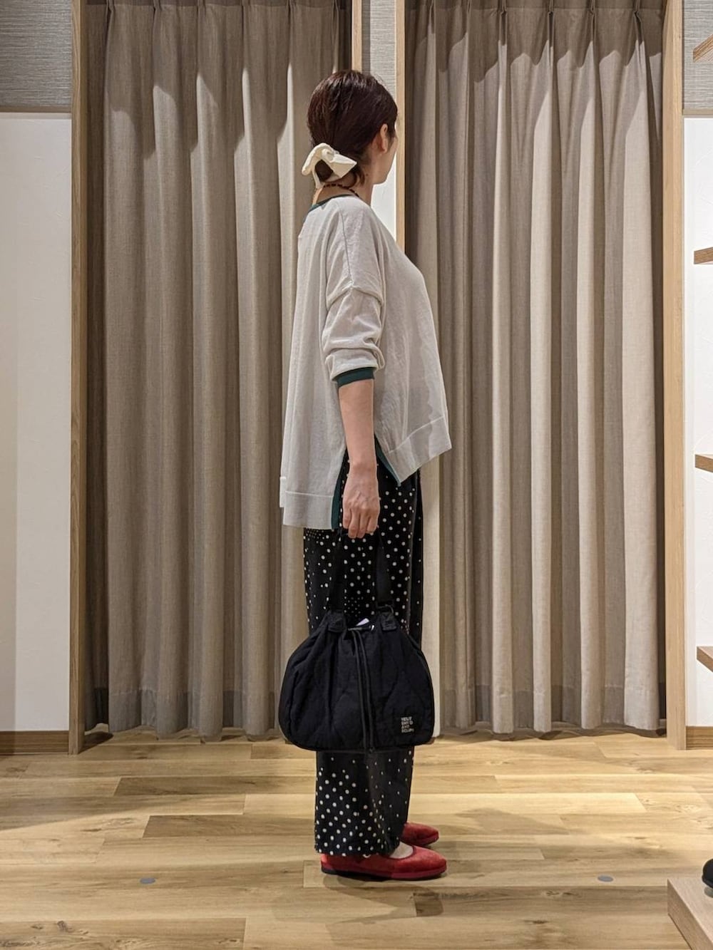 レッド系のその他シューズ、グレー系のニット/セーター、ブラック系のその他パンツを着用したレディースの秋コーディネートの2枚目の写真