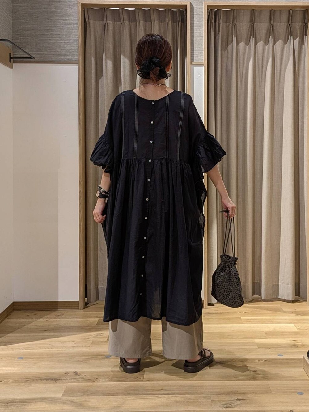 ブラウン系のサンダル、ベージュ系のその他パンツ、ブラック系のワンピースを着用したレディースの夏コーディネートの3枚目の写真
