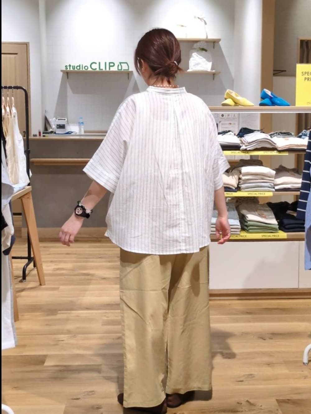 ピンク系のトートバッグ、ブラウン系のパンプス、ベージュ系のその他パンツを着用したレディースの春コーディネートの2枚目の写真