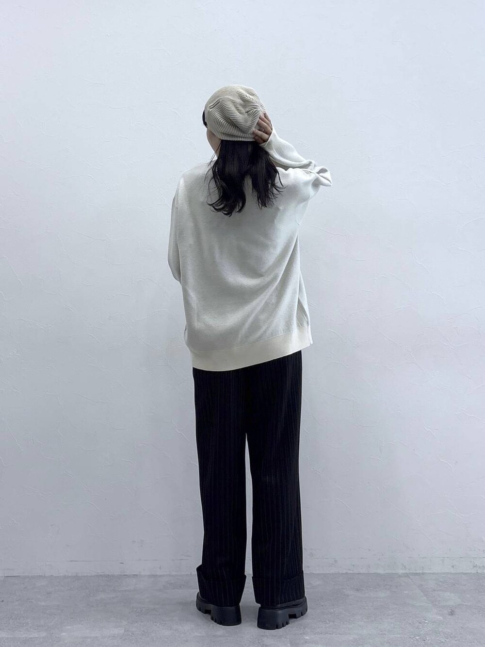 ホワイト系のニット/セーター、ブラック系のローファー、ブラック系のスラックスを着用したレディースの秋コーディネートの2枚目の写真