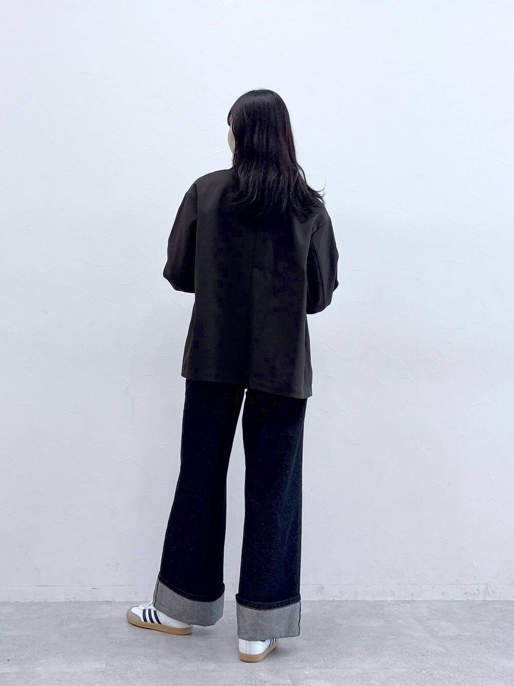 ブルー系のデニムパンツ、ホワイト系のTシャツ/カットソー、ブラウン系のテーラードジャケットを着用したレディースの秋コーディネートの3枚目の写真