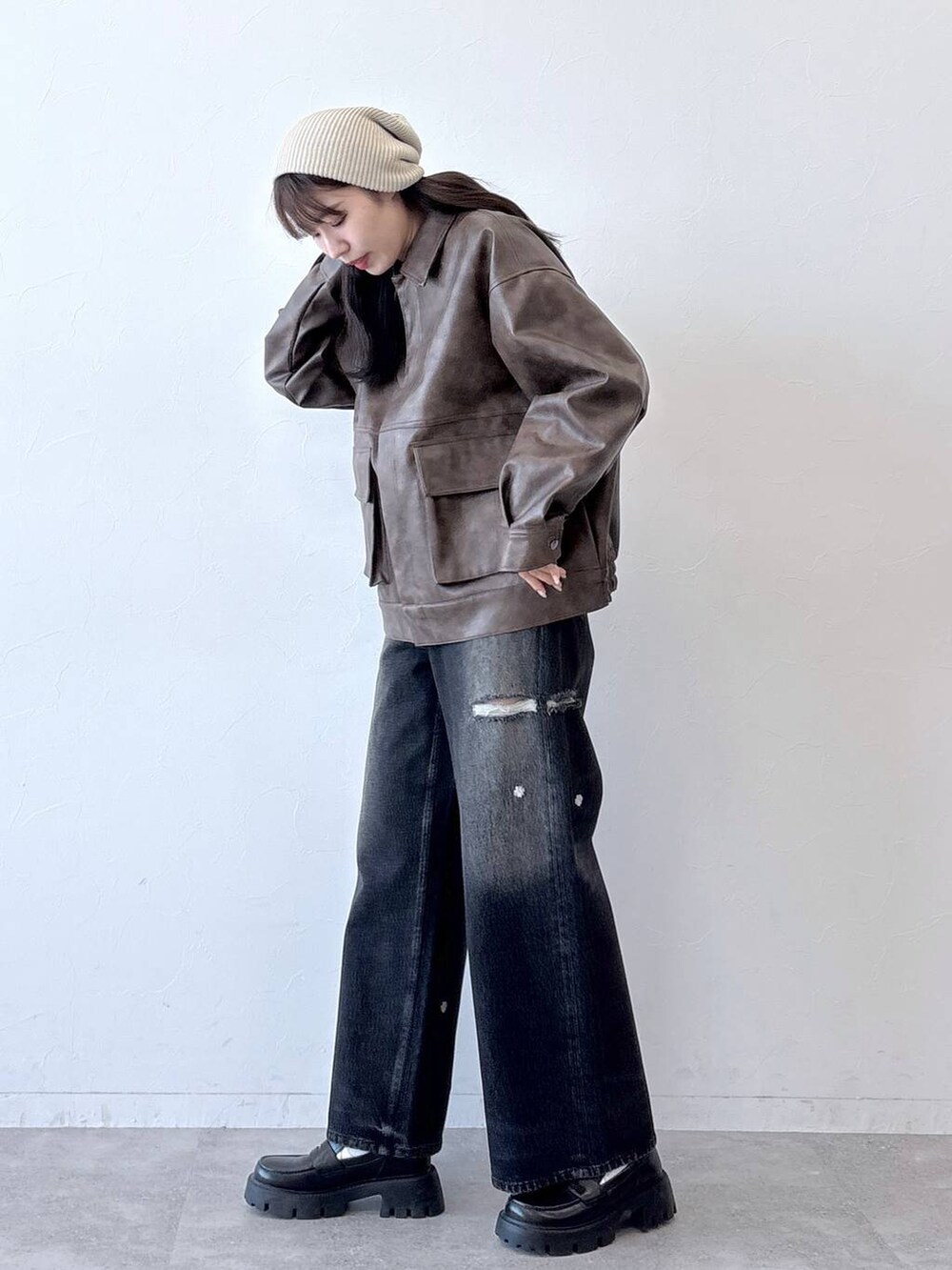 ブラウン系のブルゾン、ブラック系のデニムパンツ、ブラック系のローファーを着用したレディースの春コーディネートの4枚目の写真