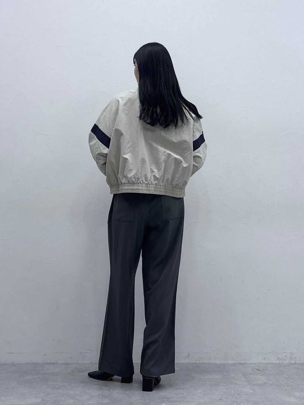 グレー系のセットアップ、ホワイト系のブルゾンを着用したレディースの冬コーディネートの3枚目の写真