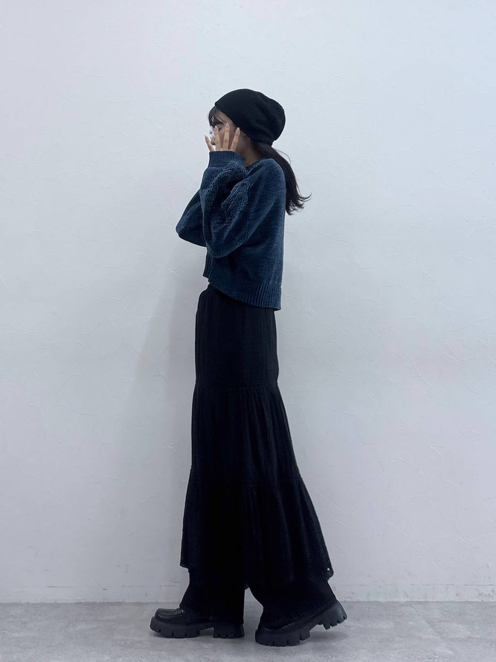 ブルー系のニット/セーター、ブラック系のデニムパンツ、ブラック系のローファーを着用したレディースの秋コーディネートの2枚目の写真