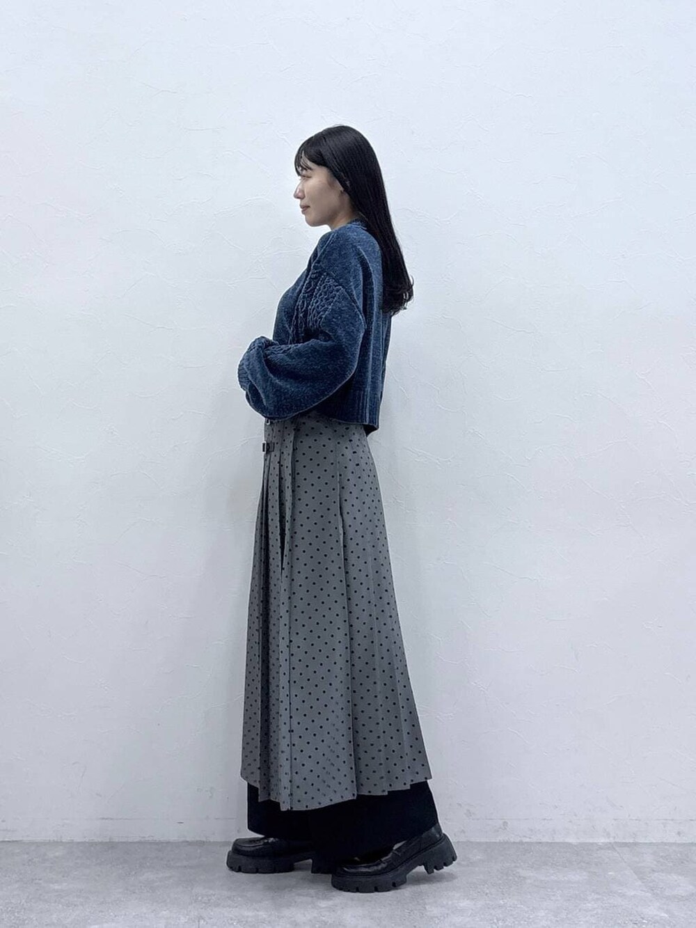 ブルー系のニット/セーター、ブラック系のローファー、ブラック系のチノパンツを着用したレディースの冬コーディネートの2枚目の写真