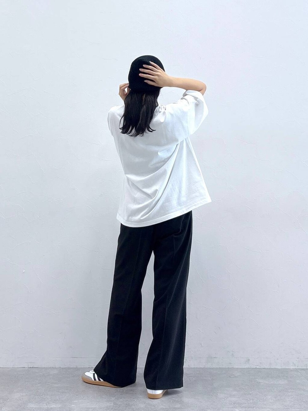 ブラック系のスラックス、ホワイト系のTシャツ/カットソー、ブラック系のニットキャップ/ビーニーを着用したレディースの夏コーディネートの3枚目の写真