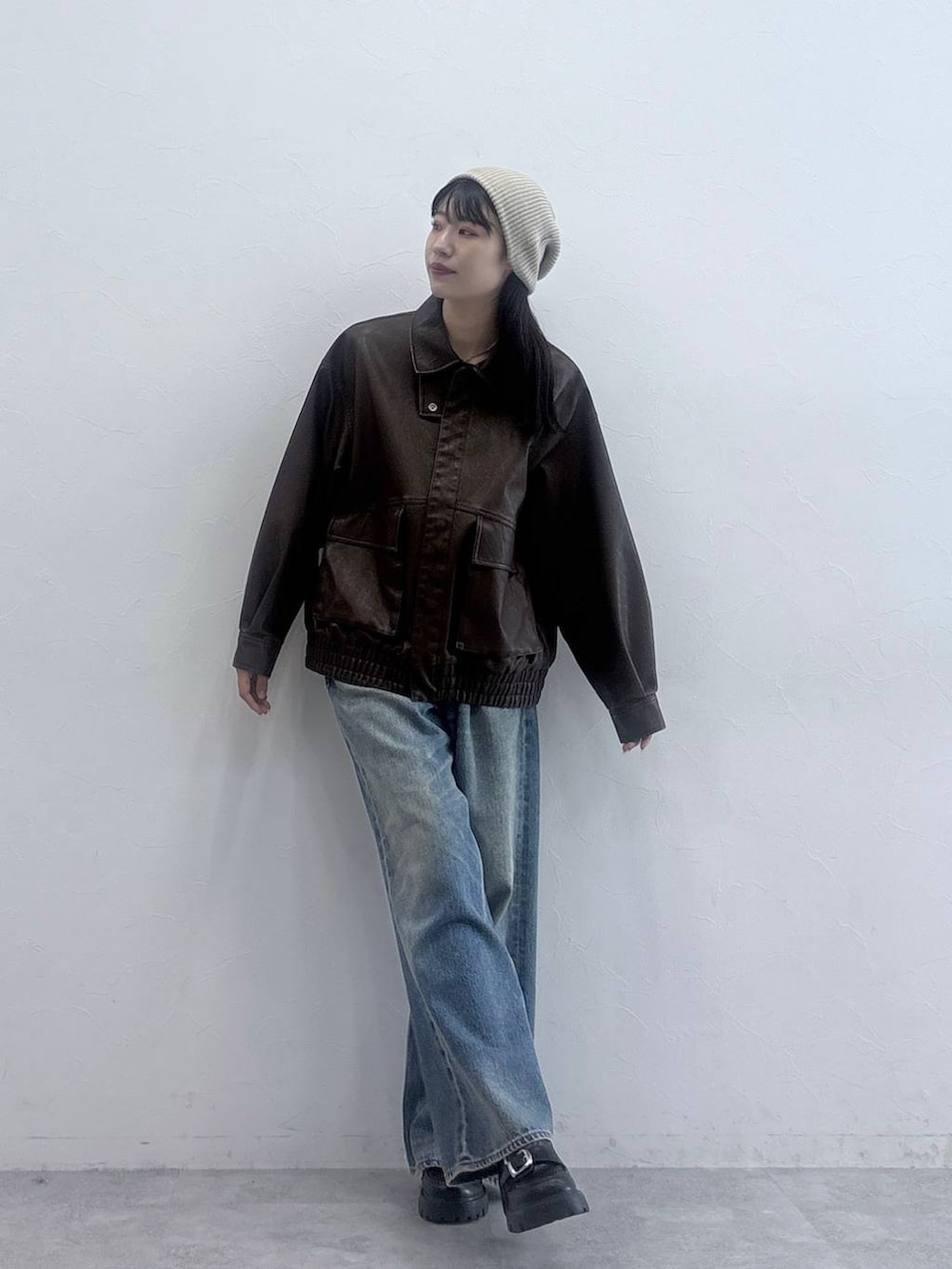 ブラック系のローファー、ブルー系のデニムパンツ、ブラウン系のブルゾンを着用したレディースの秋コーディネートの3枚目の写真