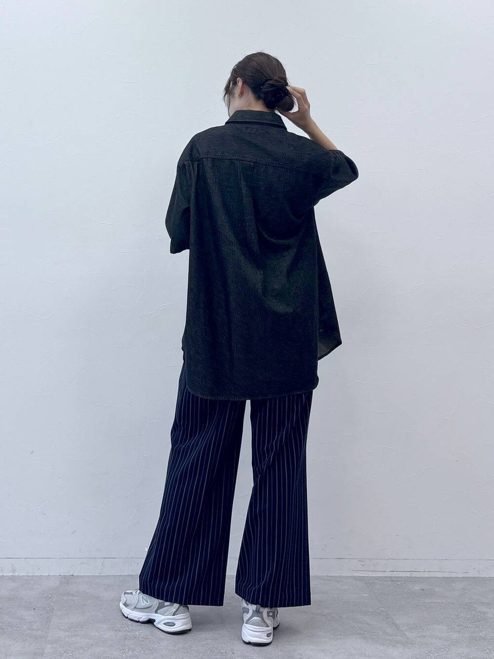 ブラック系のシャツ/ブラウス、ブルー系のスラックスを着用したレディースの春コーディネートの2枚目の写真