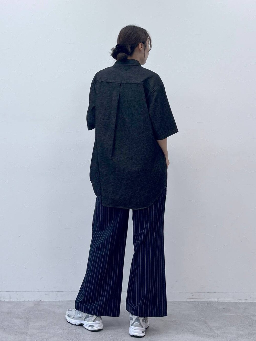 ブラック系のシャツ/ブラウス、ブルー系のスラックスを着用したレディースの春コーディネートの4枚目の写真