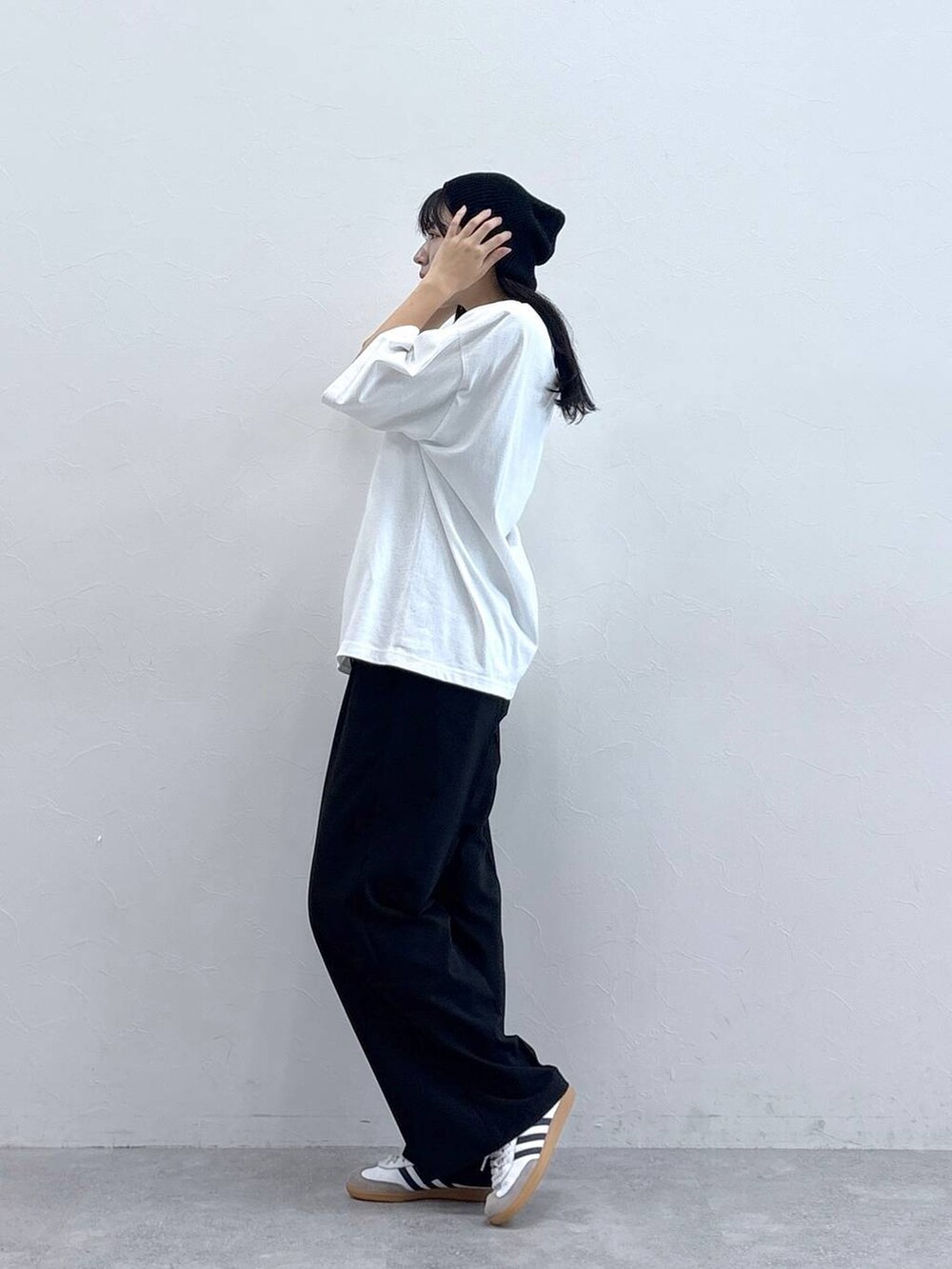 ブラック系のスラックス、ホワイト系のTシャツ/カットソー、ブラック系のニットキャップ/ビーニーを着用したレディースの夏コーディネートの2枚目の写真