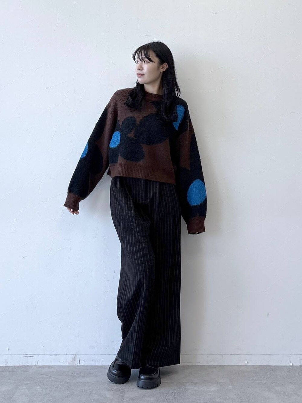 ブラック系のローファー、ブラウン系のニット/セーター、ブラック系のスラックスを着用したレディースの秋コーディネートの4枚目の写真