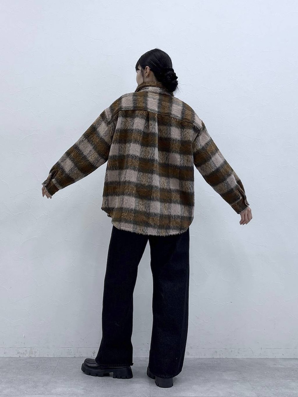 ブラック系のデニムパンツ、ブラック系のローファー、ピンク系のブルゾンを着用したレディースの秋コーディネートの4枚目の写真