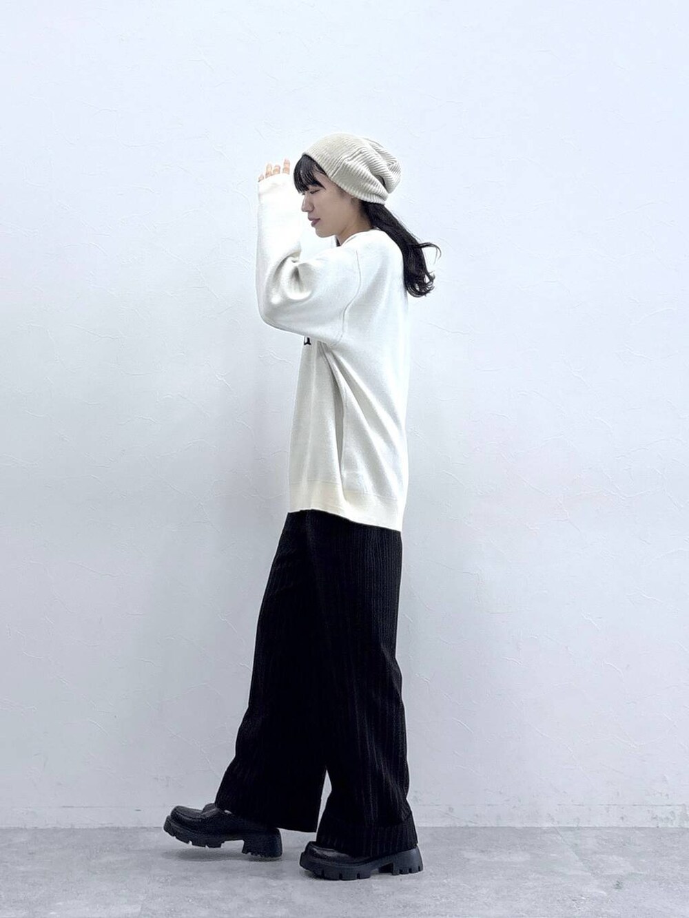 ホワイト系のニット/セーター、ブラック系のローファー、ブラック系のスラックスを着用したレディースの秋コーディネートの4枚目の写真