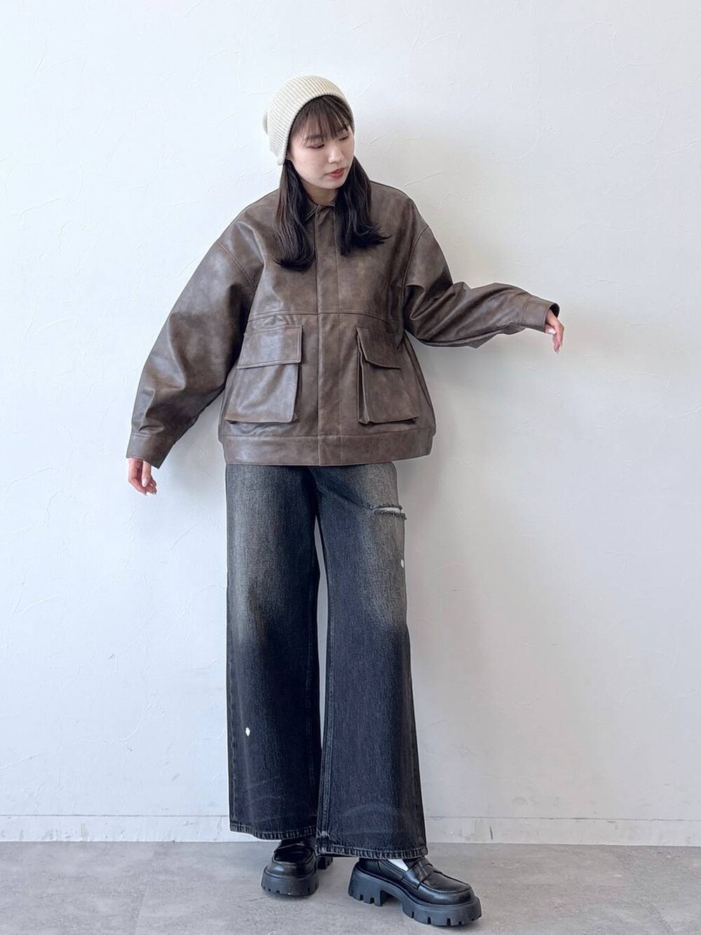 ブラウン系のブルゾン、ブラック系のデニムパンツ、ブラック系のローファーを着用したレディースの春コーディネートの5枚目の写真