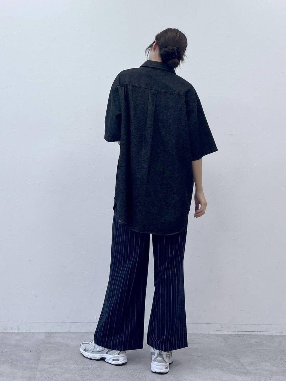 ブラック系のシャツ/ブラウス、ブルー系のスラックスを着用したレディースの春コーディネートの5枚目の写真