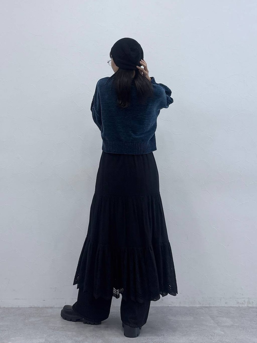 ブルー系のニット/セーター、ブラック系のデニムパンツ、ブラック系のローファーを着用したレディースの秋コーディネートの4枚目の写真