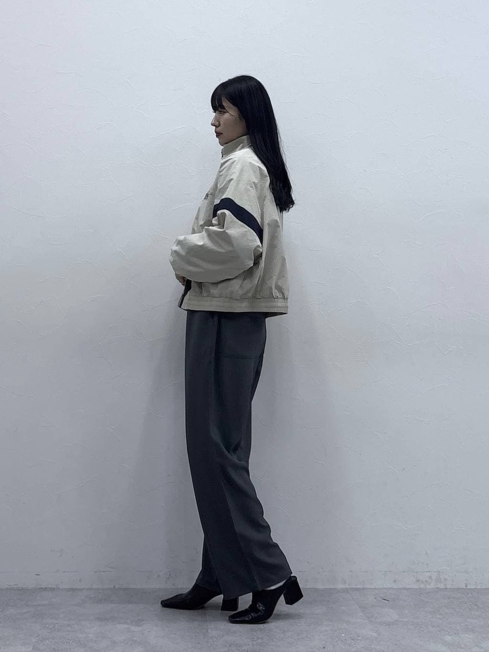 グレー系のセットアップ、ホワイト系のブルゾンを着用したレディースの冬コーディネートの2枚目の写真