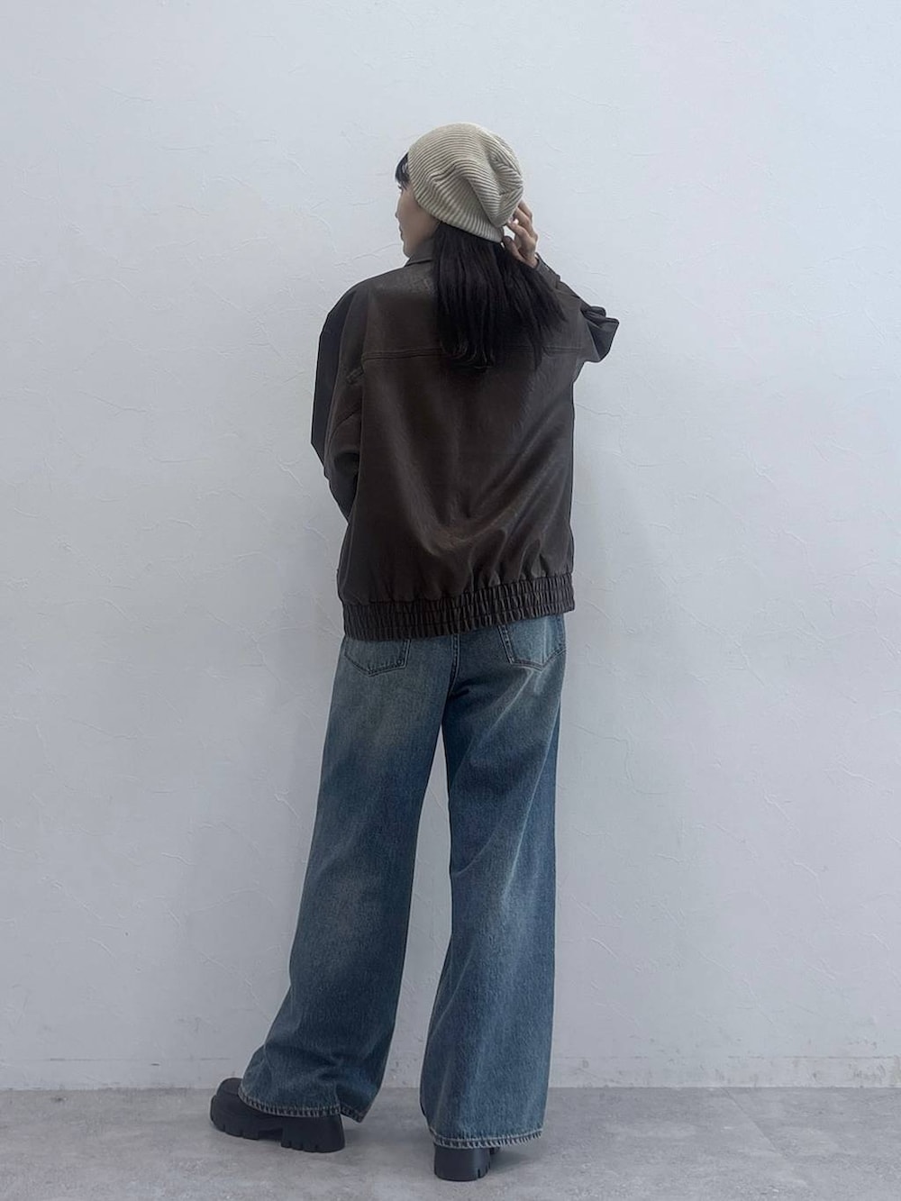 ブラック系のローファー、ブルー系のデニムパンツ、ブラウン系のブルゾンを着用したレディースの秋コーディネートの4枚目の写真