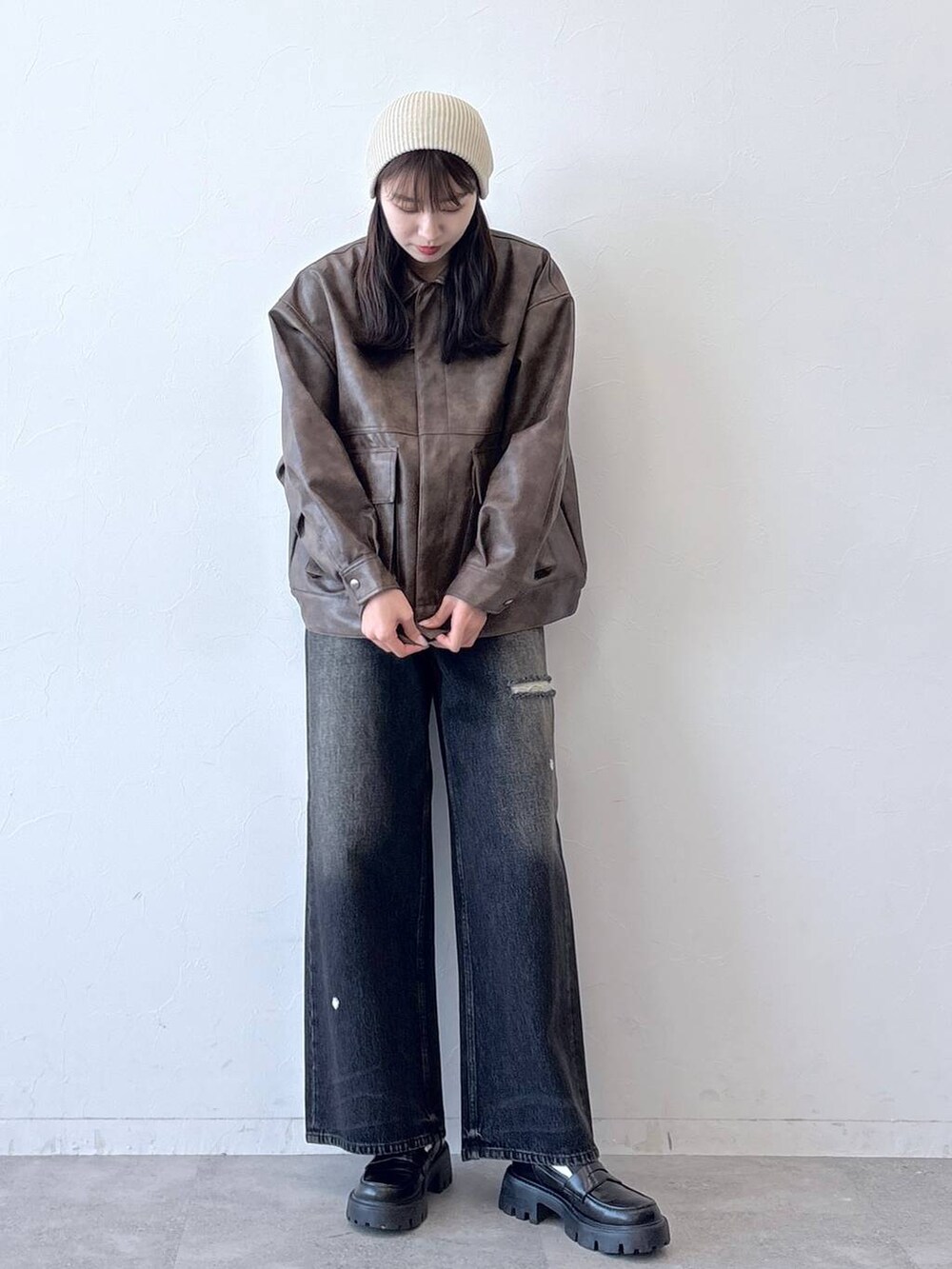 ブラウン系のブルゾン、ブラック系のデニムパンツ、ブラック系のローファーを着用したレディースの春コーディネートの7枚目の写真