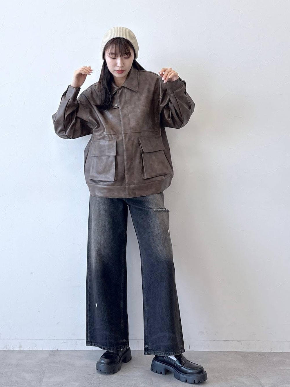 ブラウン系のブルゾン、ブラック系のデニムパンツ、ブラック系のローファーを着用したレディースの春コーディネートの3枚目の写真