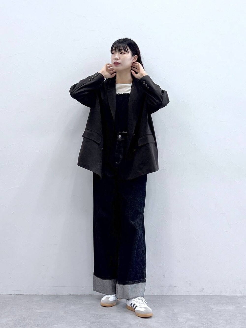 ブルー系のデニムパンツ、ホワイト系のTシャツ/カットソー、ブラウン系のテーラードジャケットを着用したレディースの秋コーディネートの2枚目の写真