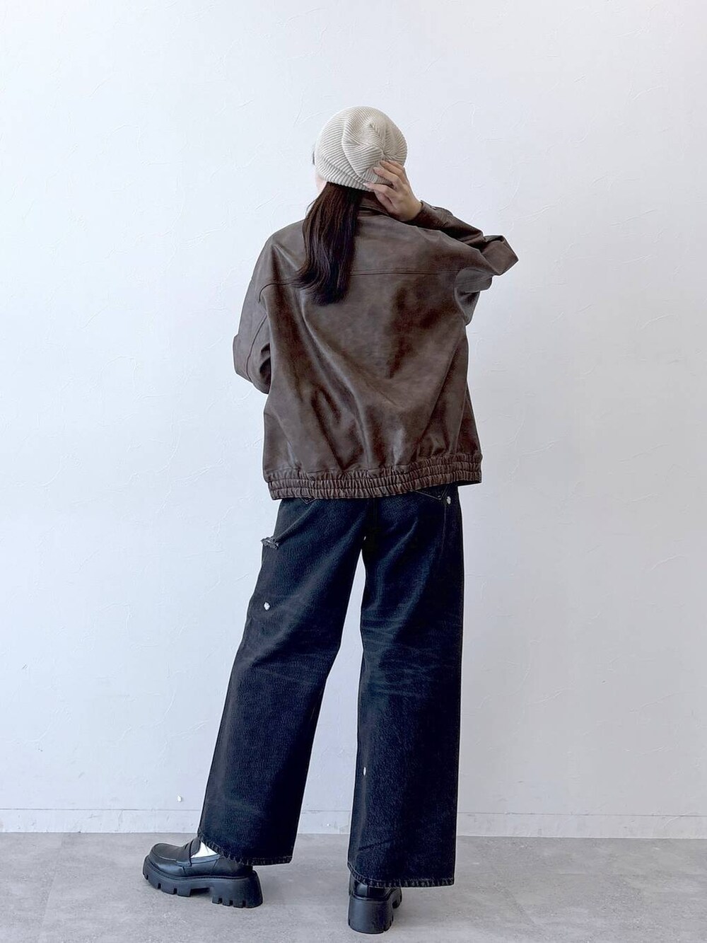 ブラウン系のブルゾン、ブラック系のデニムパンツ、ブラック系のローファーを着用したレディースの春コーディネートの6枚目の写真