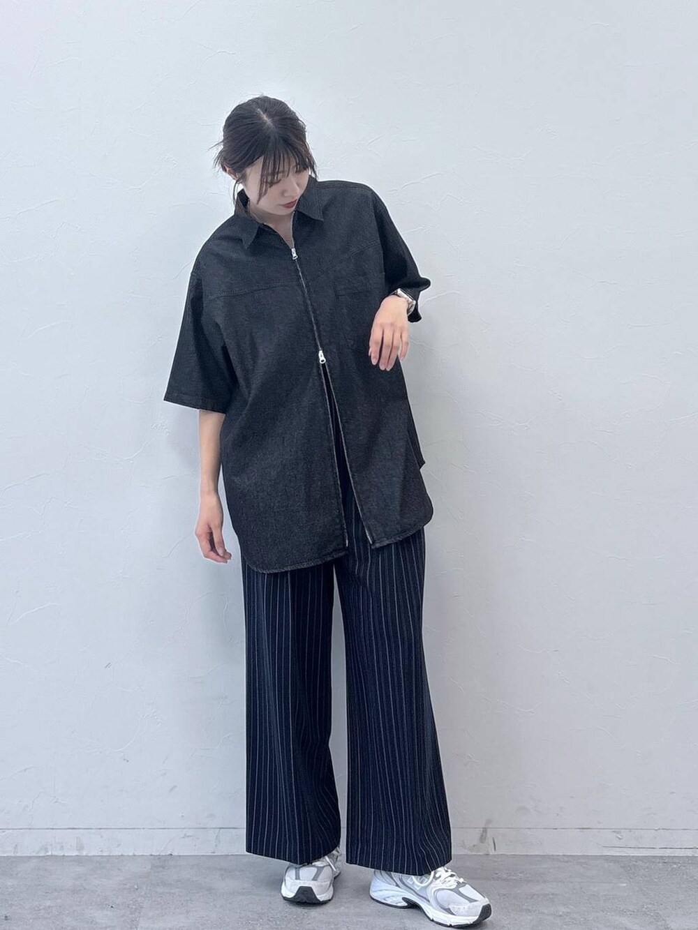 ブラック系のシャツ/ブラウス、ブルー系のスラックスを着用したレディースの春コーディネートの3枚目の写真