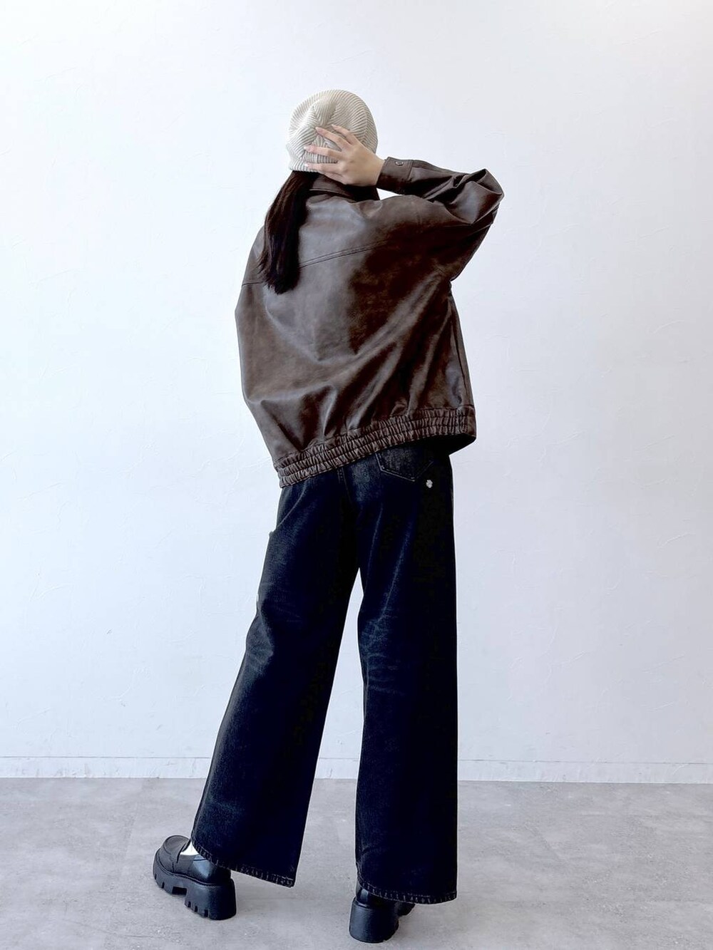 ブラウン系のブルゾン、ブラック系のデニムパンツ、ブラック系のローファーを着用したレディースの春コーディネートの2枚目の写真