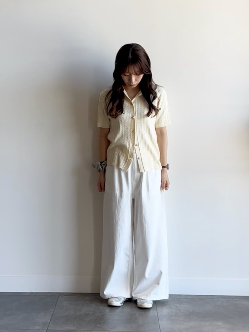ホワイト系のニット/セーター、ホワイト系のデニムパンツを着用したレディースの夏コーディネートの2枚目の写真
