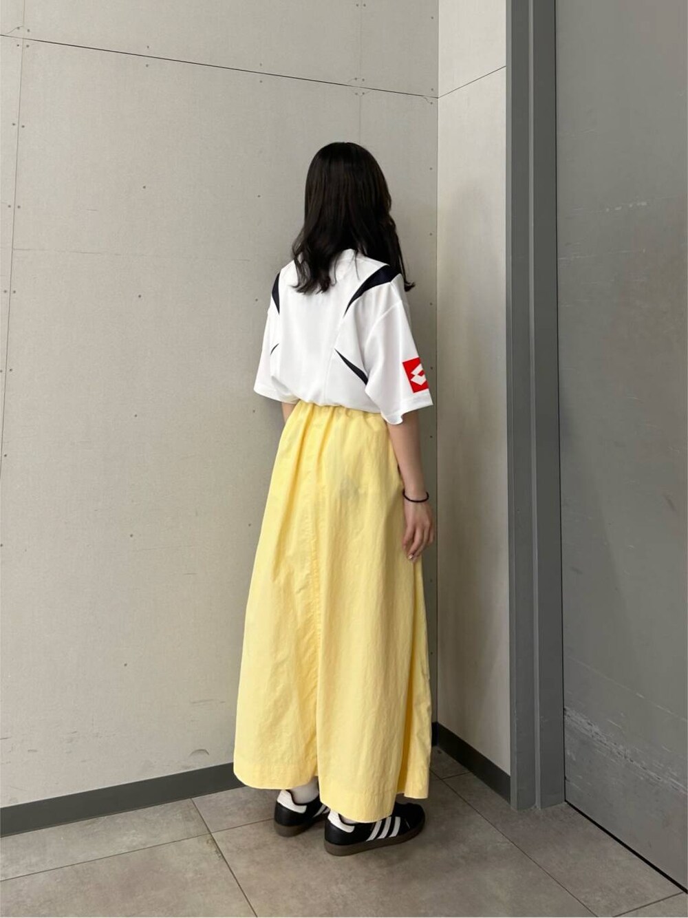 イエロー系のスカートを着用したレディースの春コーディネートの3枚目の写真