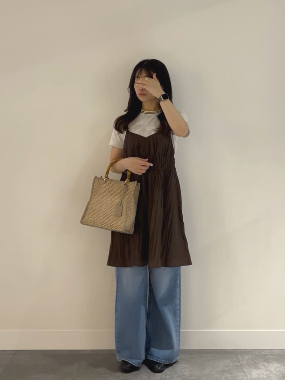 ブルー系のデニムパンツ、ブラック系のローファー、ベージュ系のショルダーバッグを着用したレディースの春コーディネートの2枚目の写真