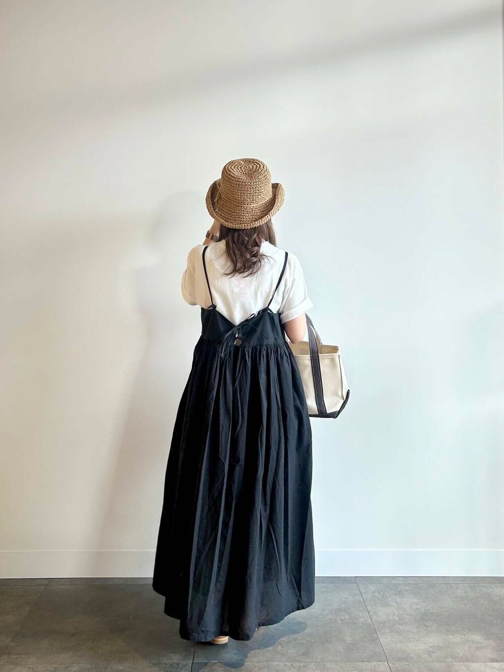 ブラウン系のサンダル、ブラック系のワンピース、ホワイト系のTシャツ/カットソーを着用したレディースの夏コーディネートの3枚目の写真