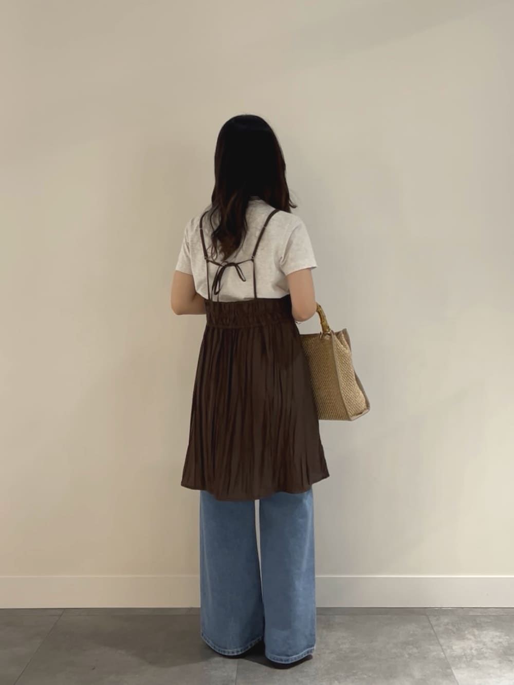 ブルー系のデニムパンツ、ブラック系のローファー、ベージュ系のショルダーバッグを着用したレディースの春コーディネートの3枚目の写真