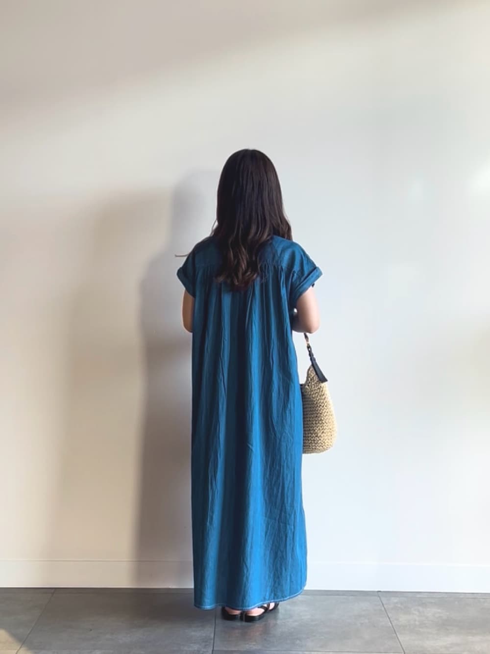 ブルー系のワンピース、ベージュ系のトートバッグ、ブラック系のサンダルを着用したレディースの夏コーディネートの3枚目の写真