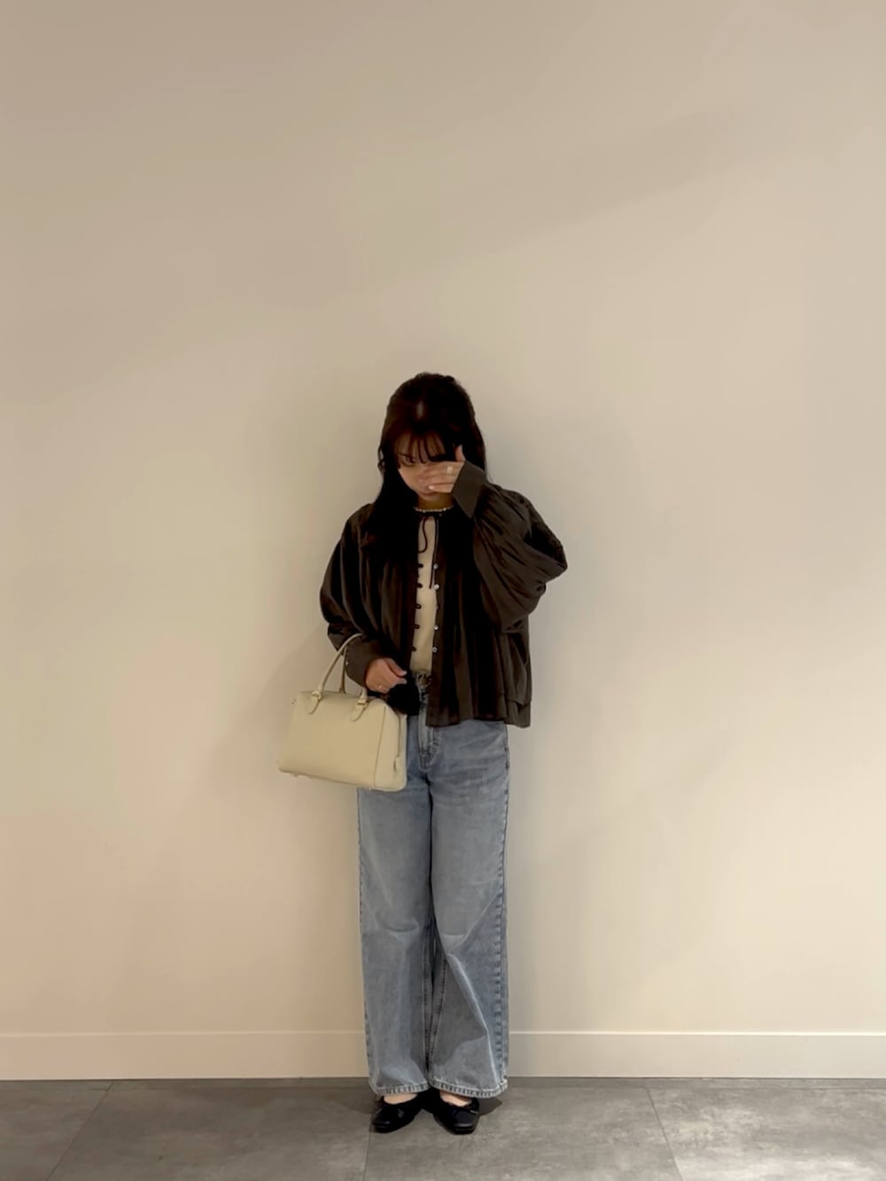 ホワイト系のボストンバッグ、ブルー系のデニムパンツ、ホワイト系のタンクトップを着用したレディースの春コーディネートの2枚目の写真