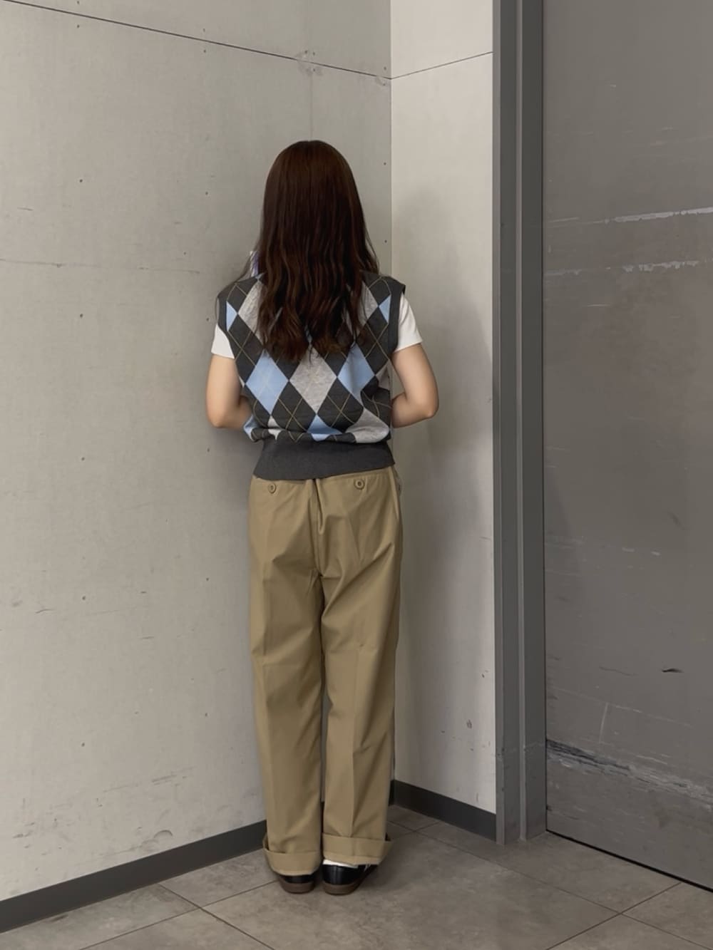 グレー系のベスト、ベージュ系のその他パンツ、ブラック系のスニーカーを着用したレディースの夏コーディネートの3枚目の写真