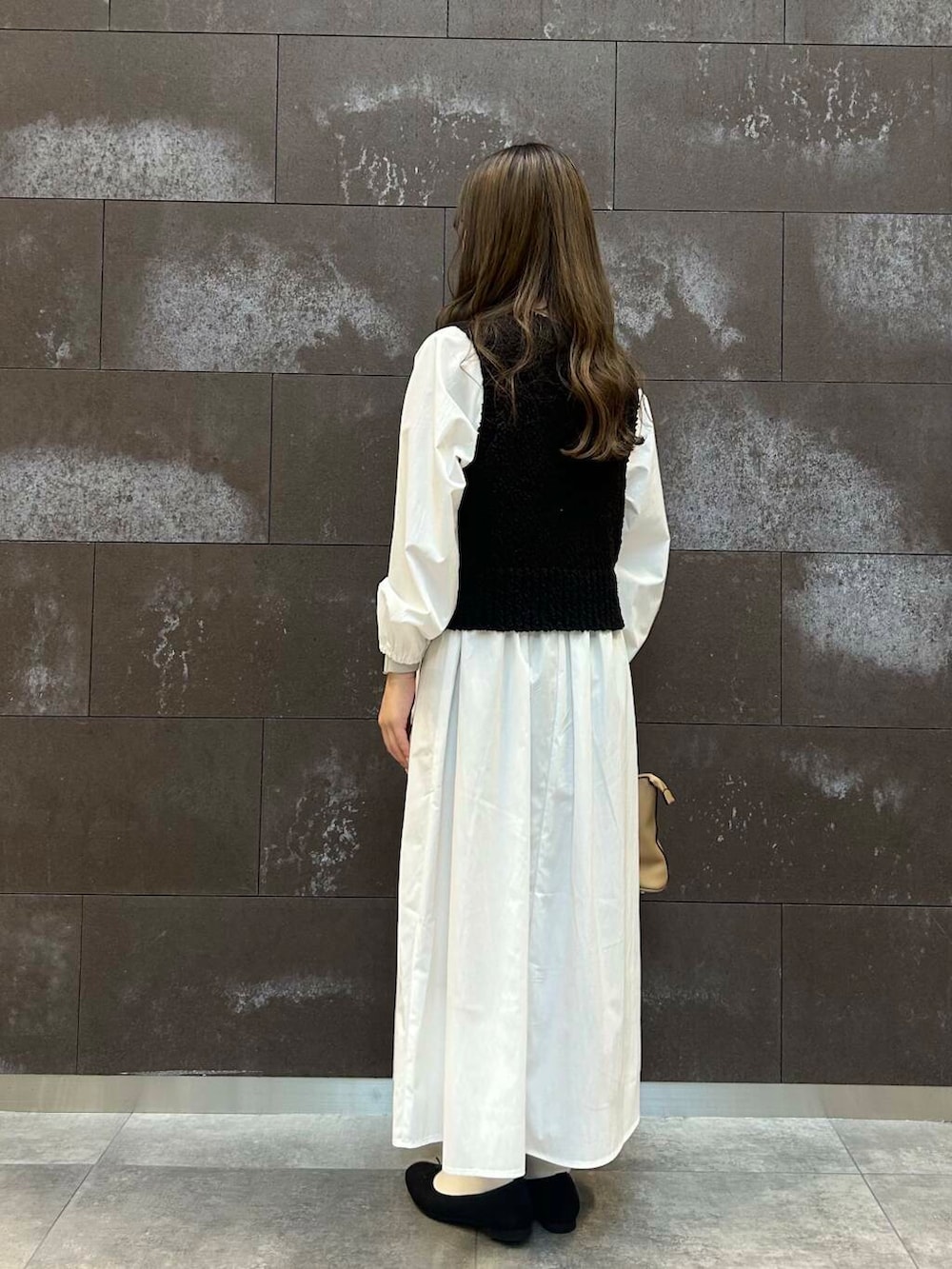 ブラック系のバレエシューズ、ブラウン系のボストンバッグ、ブラック系のワンピースを着用したレディースの冬コーディネートの3枚目の写真