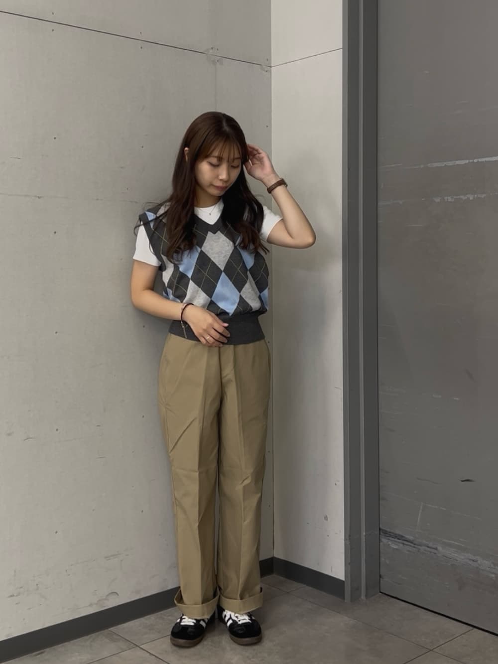 グレー系のベスト、ベージュ系のその他パンツ、ブラック系のスニーカーを着用したレディースの夏コーディネートの2枚目の写真