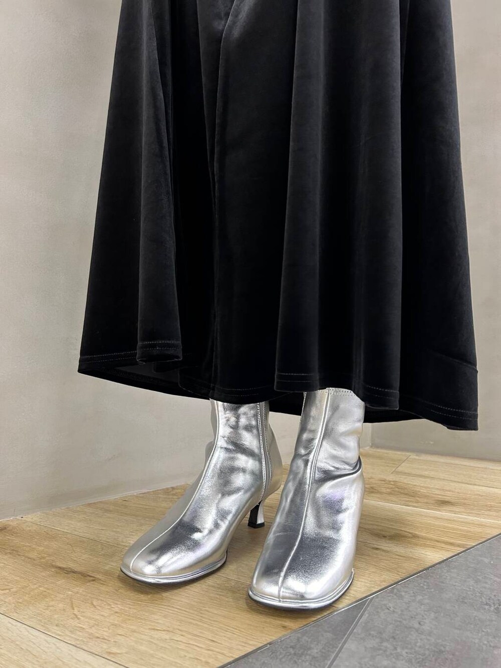 シルバー系のブーツ、ブラック系のスカート、シルバー系のショルダーバッグを着用したレディースの冬コーディネートの6枚目の写真